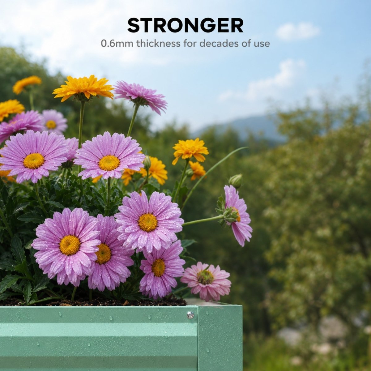 Vibrant pink and yellow flowers growing in a 0.6mm thick heavy-duty metal raised planter box built for decades of use.
