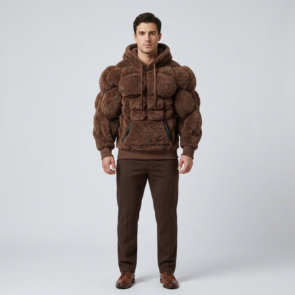 A male model wears the grey Kouvr Titan Sherpa Muscle Hoodie with padded six-pack details.