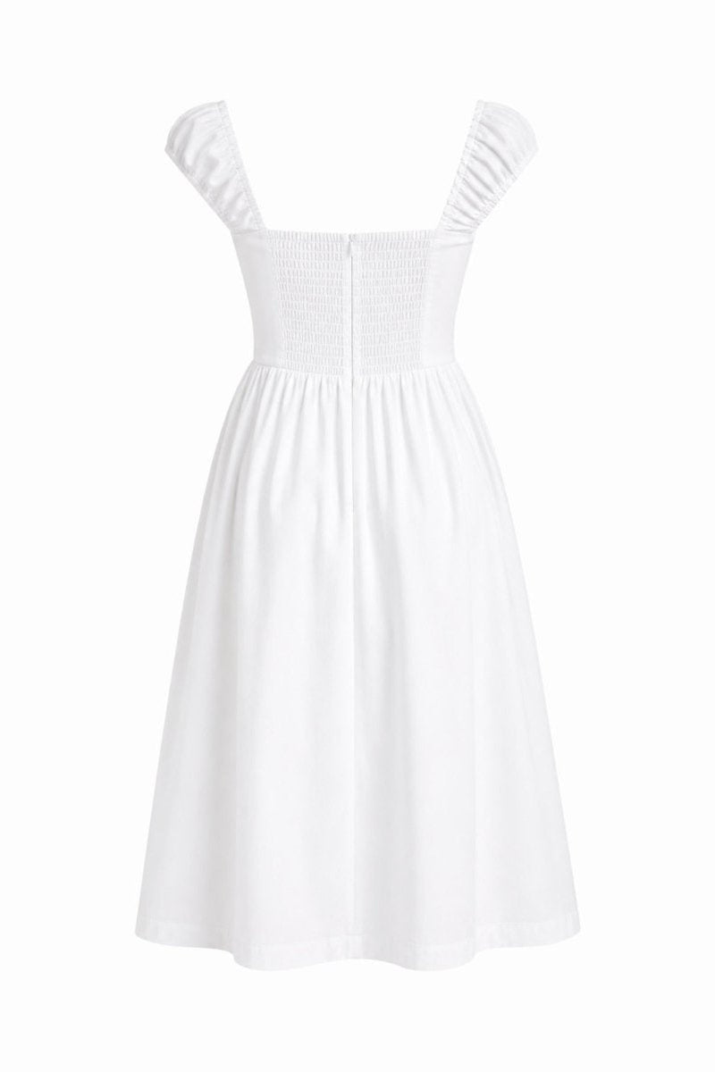 A white sleeveless dress with a smocked bodice and ruffled shoulder straps, shown against a plain white background.