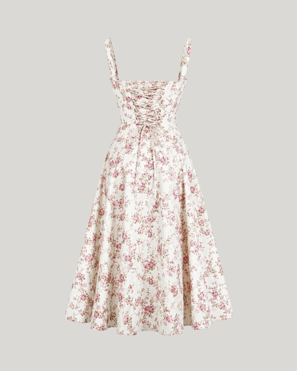 A sleeveless A-line midi dress with a cream base and a pink and red floral print, featuring a lace-up front and thin shoulder straps, shown against a solid gray background.