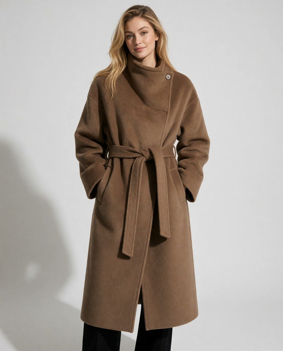 Front view of a beautiful woman wearing a long amberluxury wool wrap coat with a tied waist belt and high funnel neck.