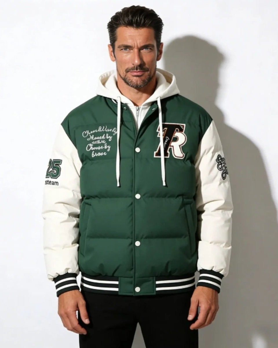 Man wearing the Angelo Hooded Puffer Varsity Jacket in green, showing the embroidered front 'R' patch and script detailing.