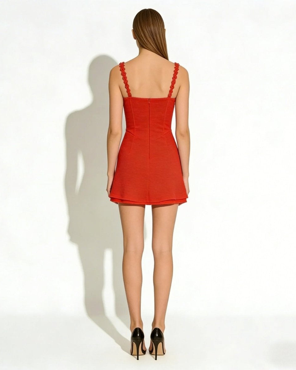Back view of a model wearing the Ariadne red mini dress, showing the scalloped straps and concealed zipper detail.