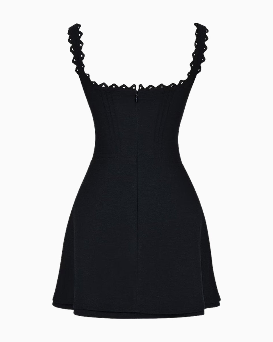 Back view flat lay of the black mini dress showing the zipper closure, paneled construction, and ariadne strap design.