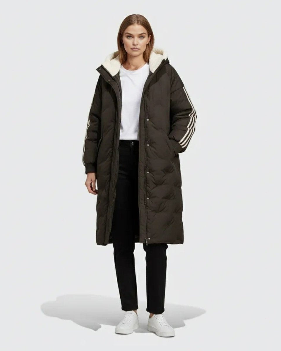 Model wearing the Arianne long black puffer coat with a white sherpa-lined hood and three white stripes on the sleeve, shown from the front.
