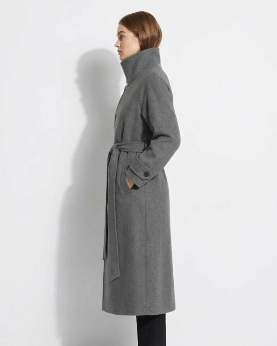 Side profile of a model in the heather grey Ashley wool coat, highlighting the high funnel neck design, full length, and elegant drape.