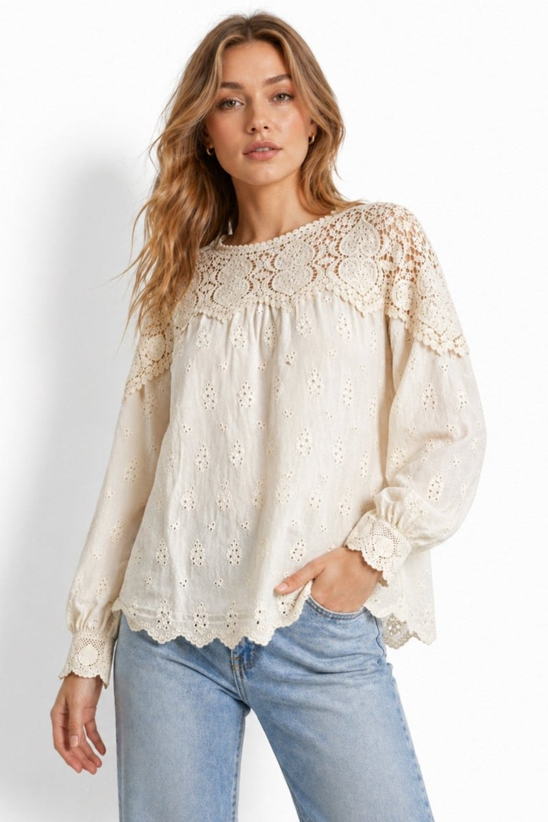 Woman wearing Fenlo Form beige crochet lace yoke broderie anglaise long sleeve blouse with light blue jeans, front lifestyle view