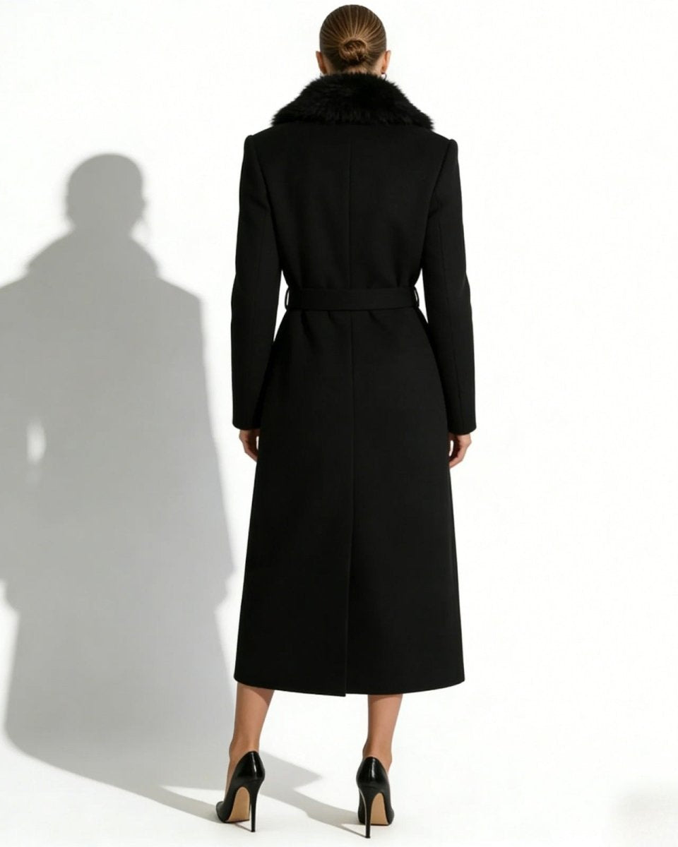 Back view of a model wearing the black wool maxi coat, showing the tailored fit and self-tie belt.