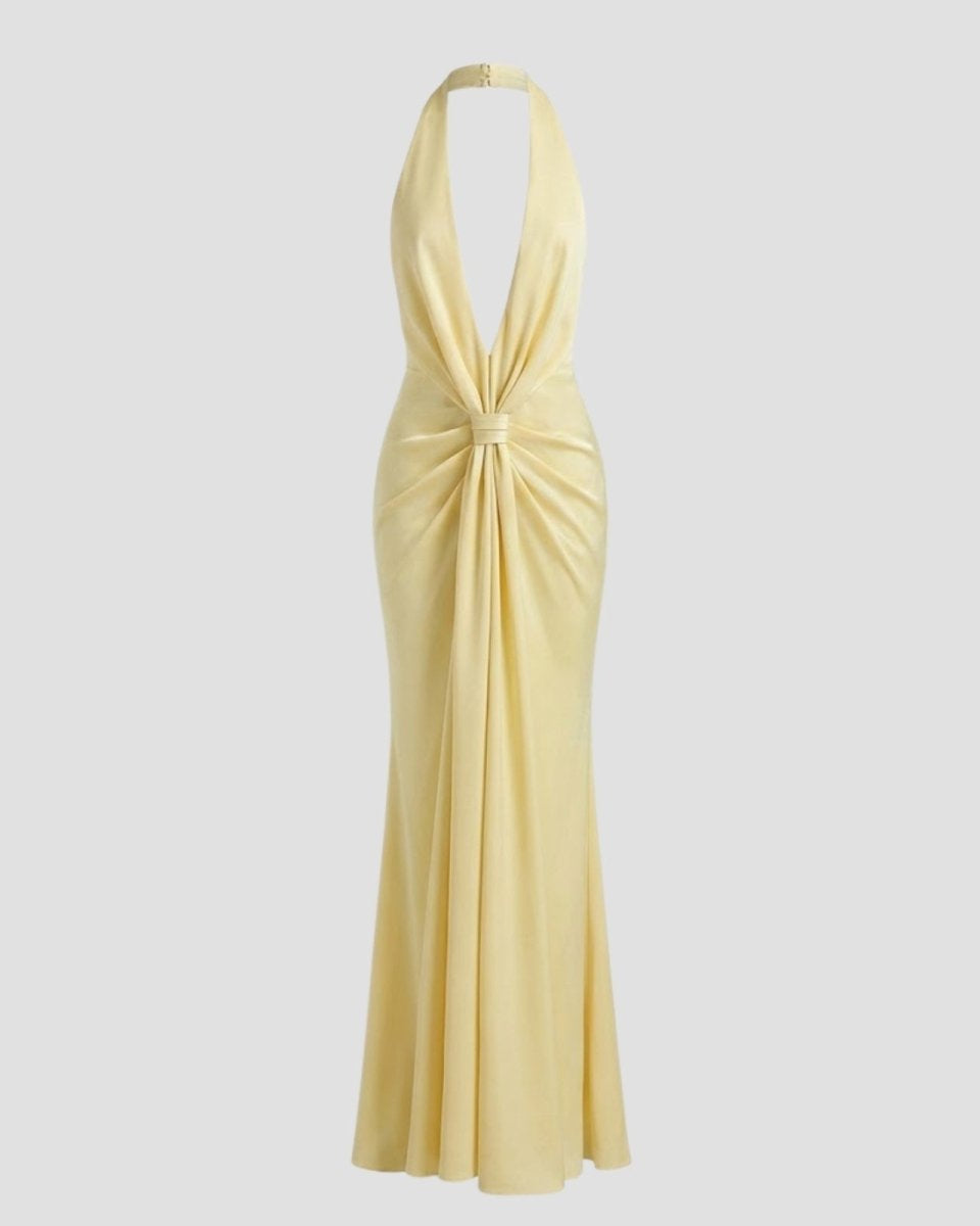 Flat lay of the Beverly halter gown in light yellow, showcasing the elegant twist knot front and plush velvet fabric.