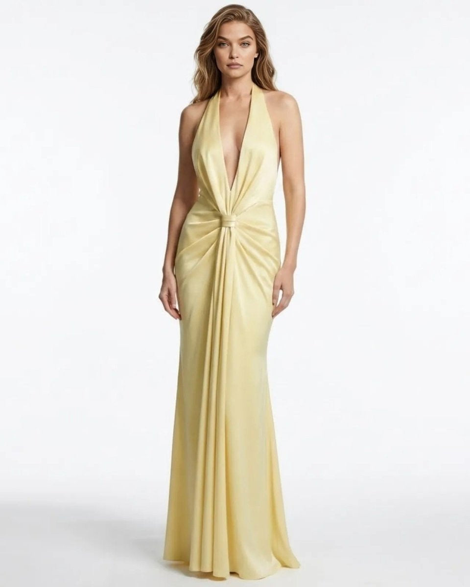 Model wearing the Beverly light yellow velvet halter gown with a plunging neckline and knot front detail.