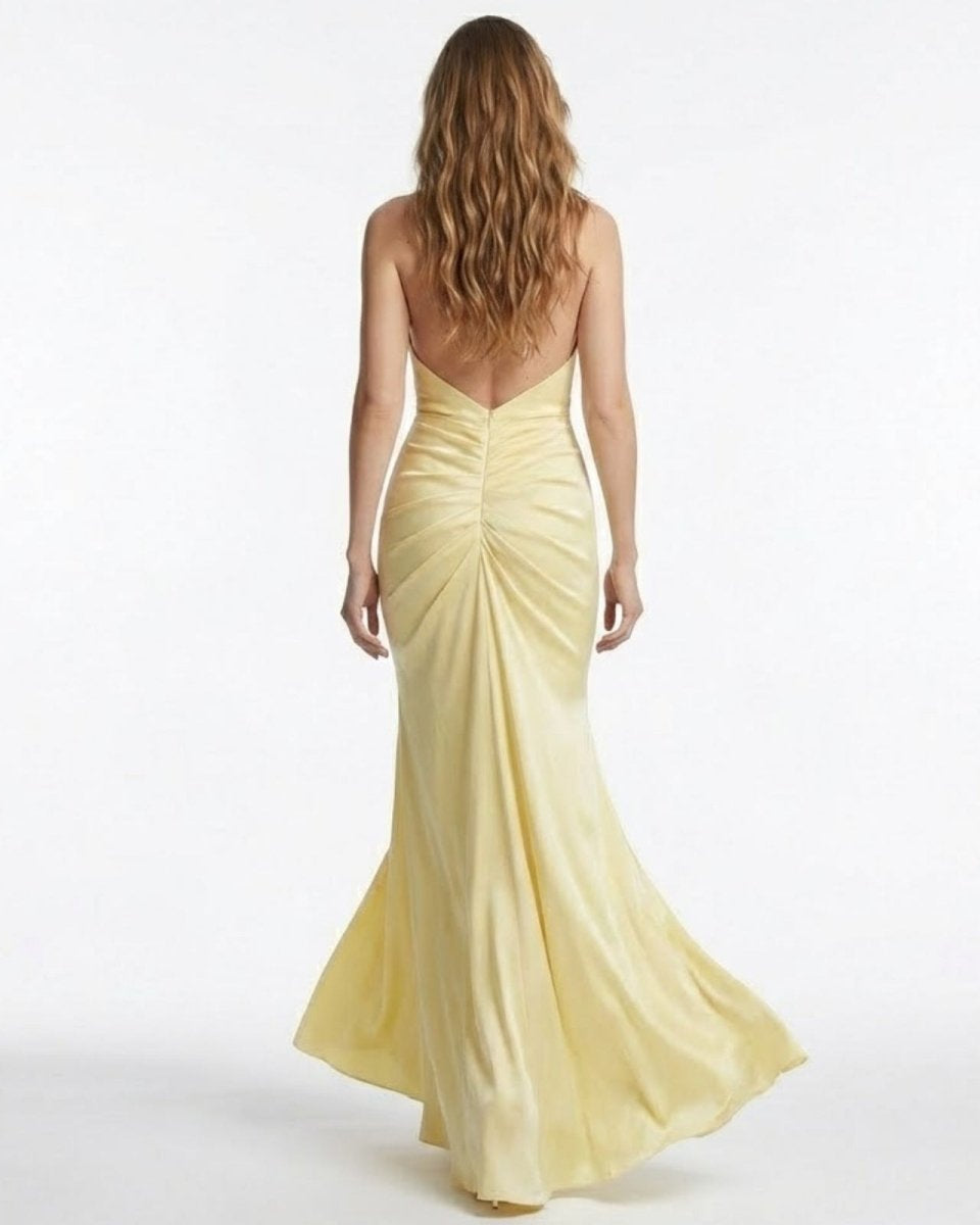 Back view of the Beverly light yellow formal dress highlighting the completely open back and flattering ruched detailing.