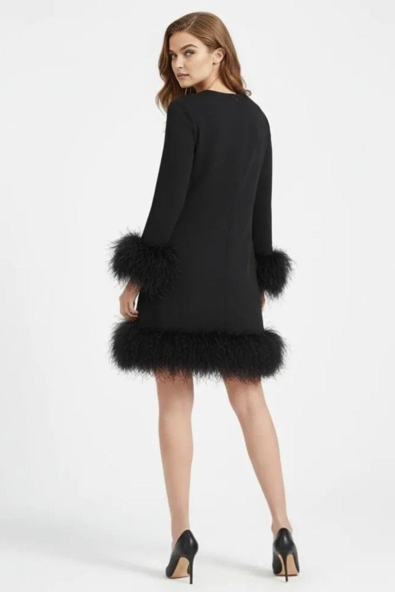 Model from behind wearing the Arica long sleeve black mini dress with voluminous feather trim on the cuffs and hem by Kouvr.