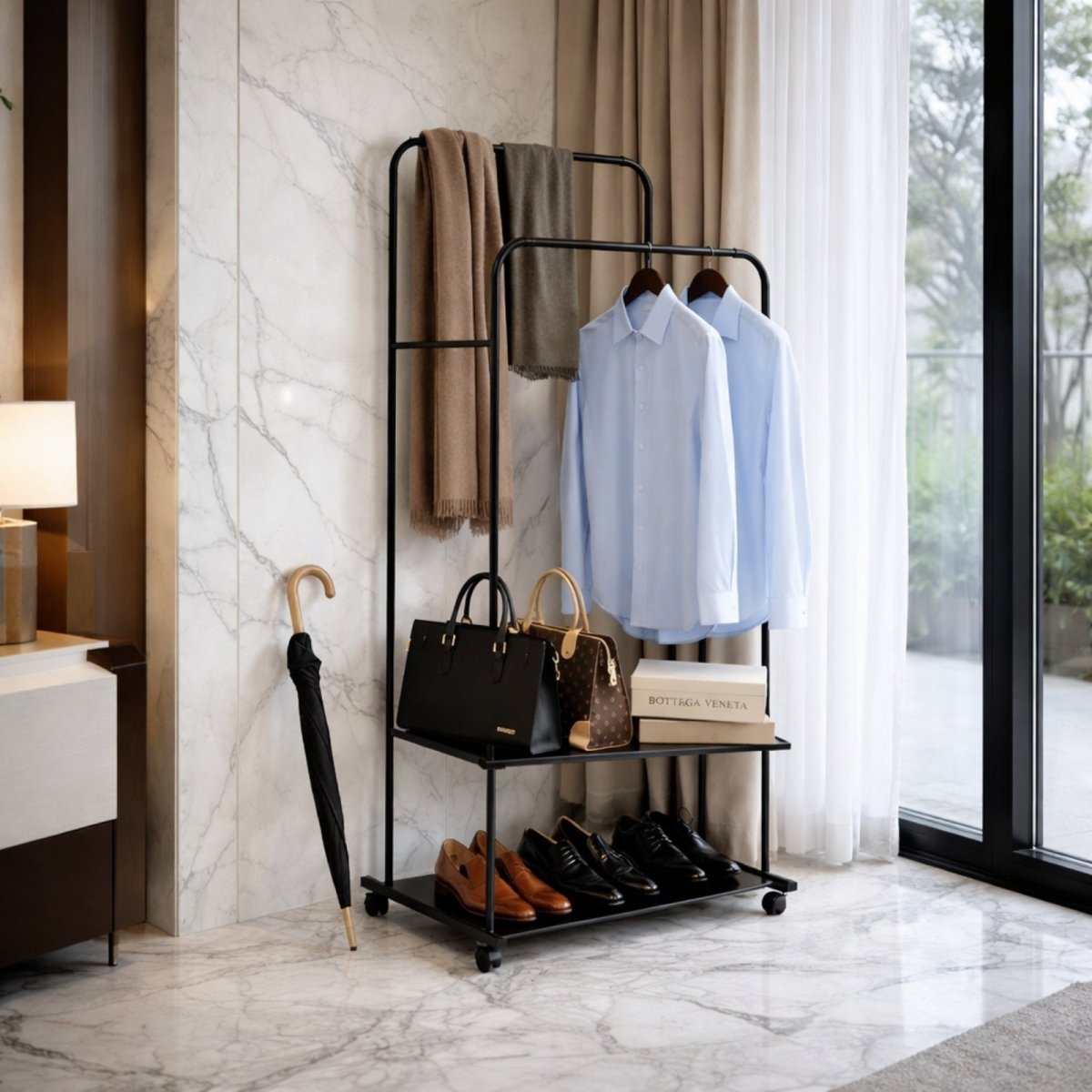 The black garment rack used as an entryway valet stand, holding scarves, shirts, designer bags, and dress shoes on its shelves against a marble wall.