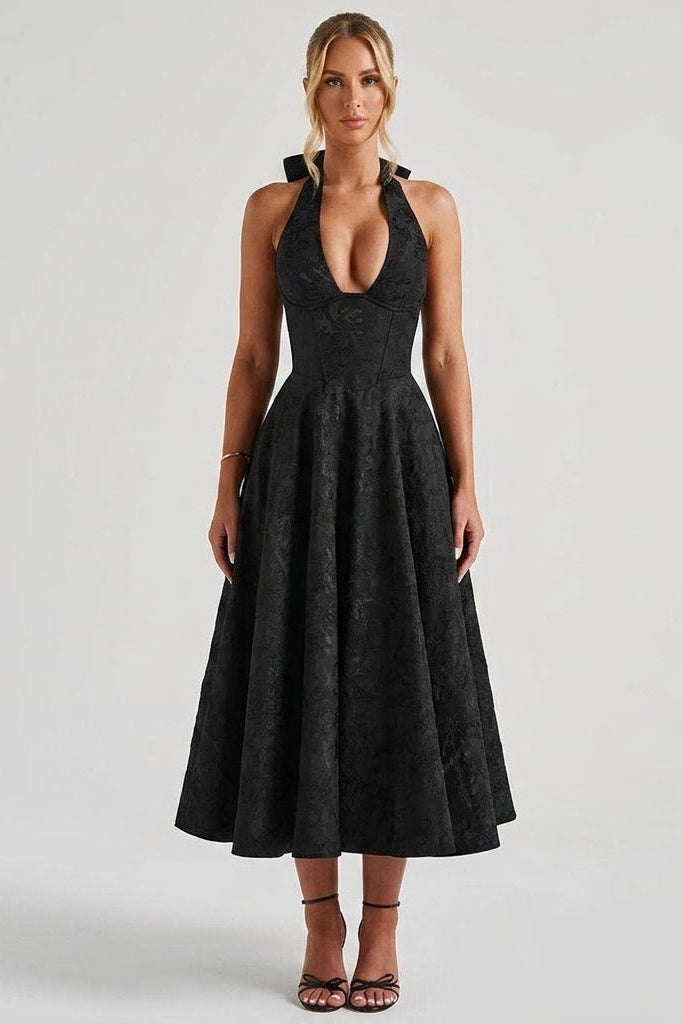 Woman wearing Kouvr black floral jacquard halter midi dress with plunging neckline and corset bodice facing forward.