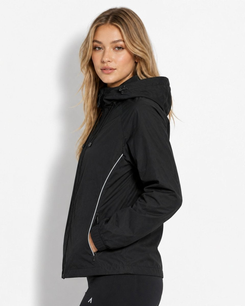 Side profile of woman wearing black zip-up windbreaker showing raglan sleeve and adjustable hood.