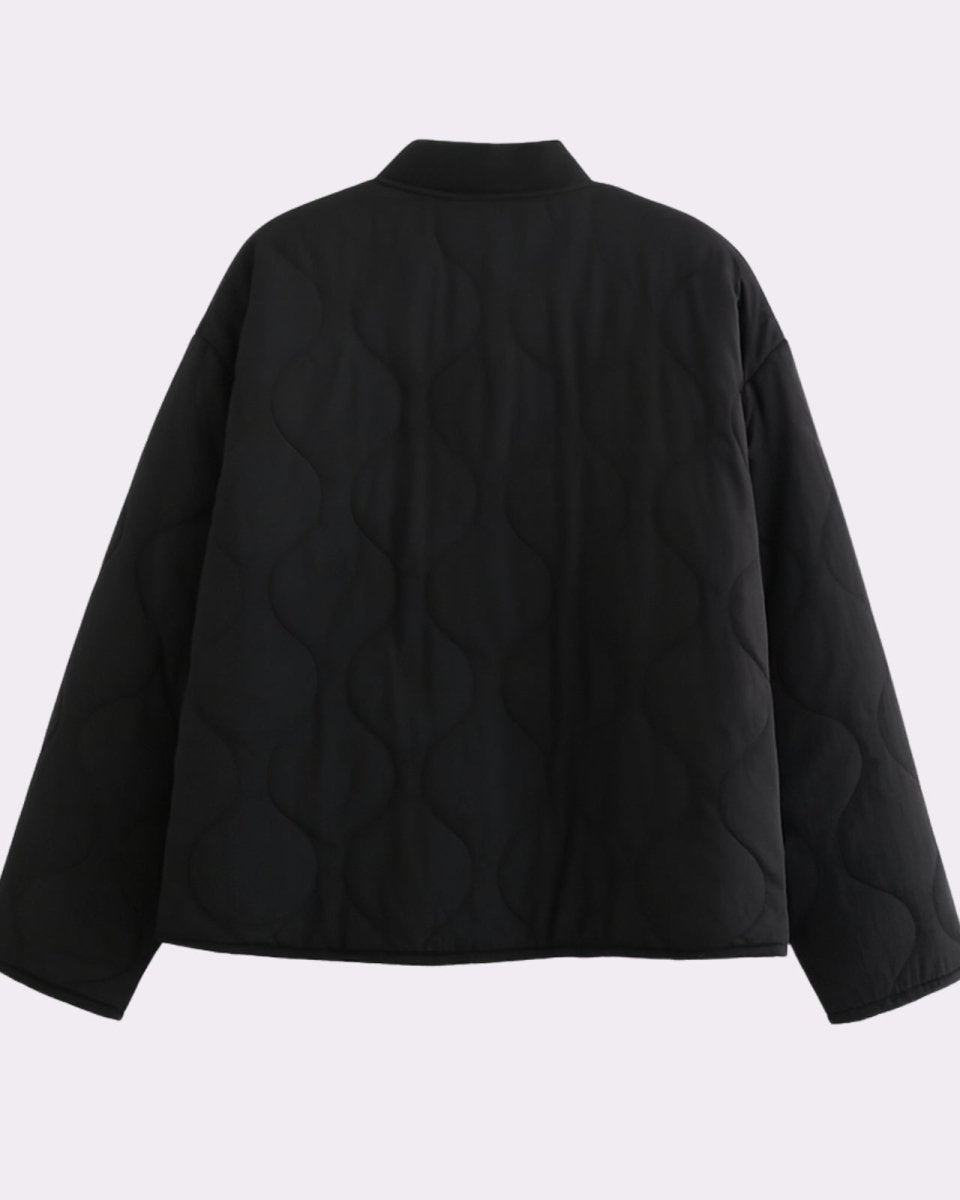 Product flat lay showing the back and signature wave quilting pattern of the black lightweight puffer jacket.