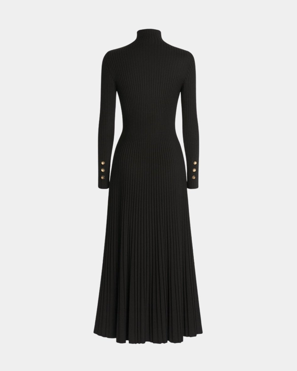 Flatlay of the black turtleneck dress emphasizing the ribbed knit texture, pleated skirt, and gold cuff buttons.