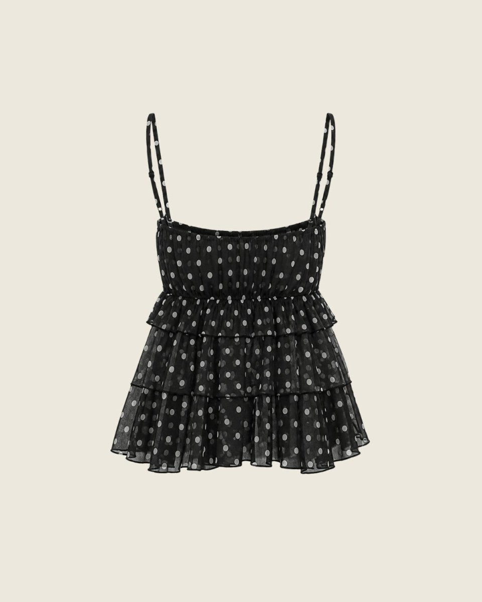 A black tiered ruffle camisole top with white polka dots and thin adjustable shoulder straps, shown flat against a light beige background.