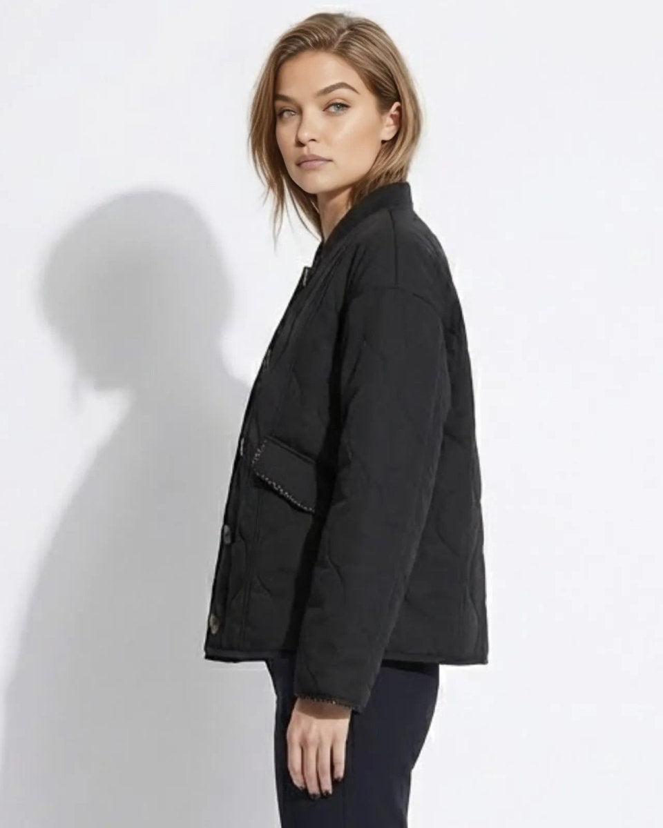 Side profile of a woman wearing the boxy fit black quilted transitional jacket