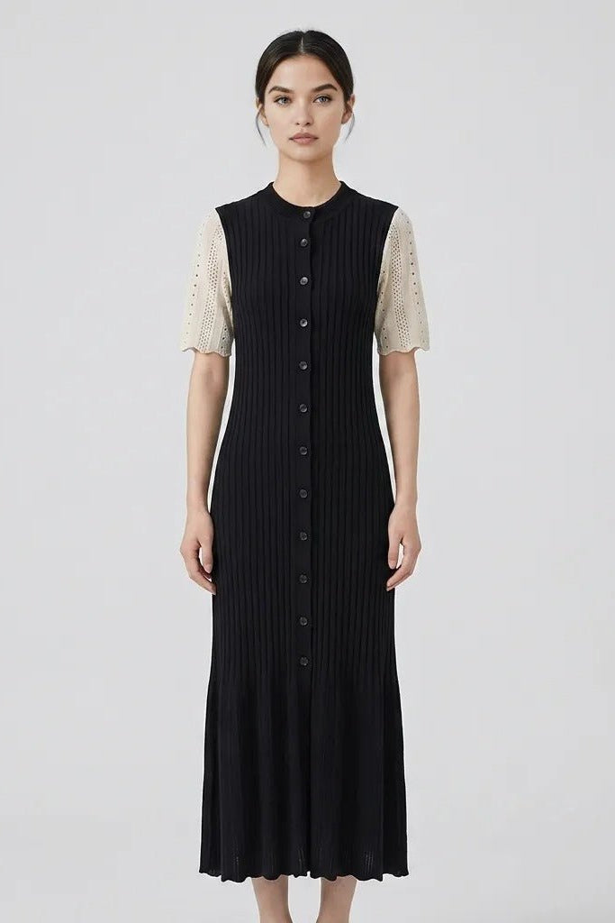 Front view of female model wearing the Fenlo Form black ribbed knit button-down maxi dress with contrasting cream pointelle short sleeves.
