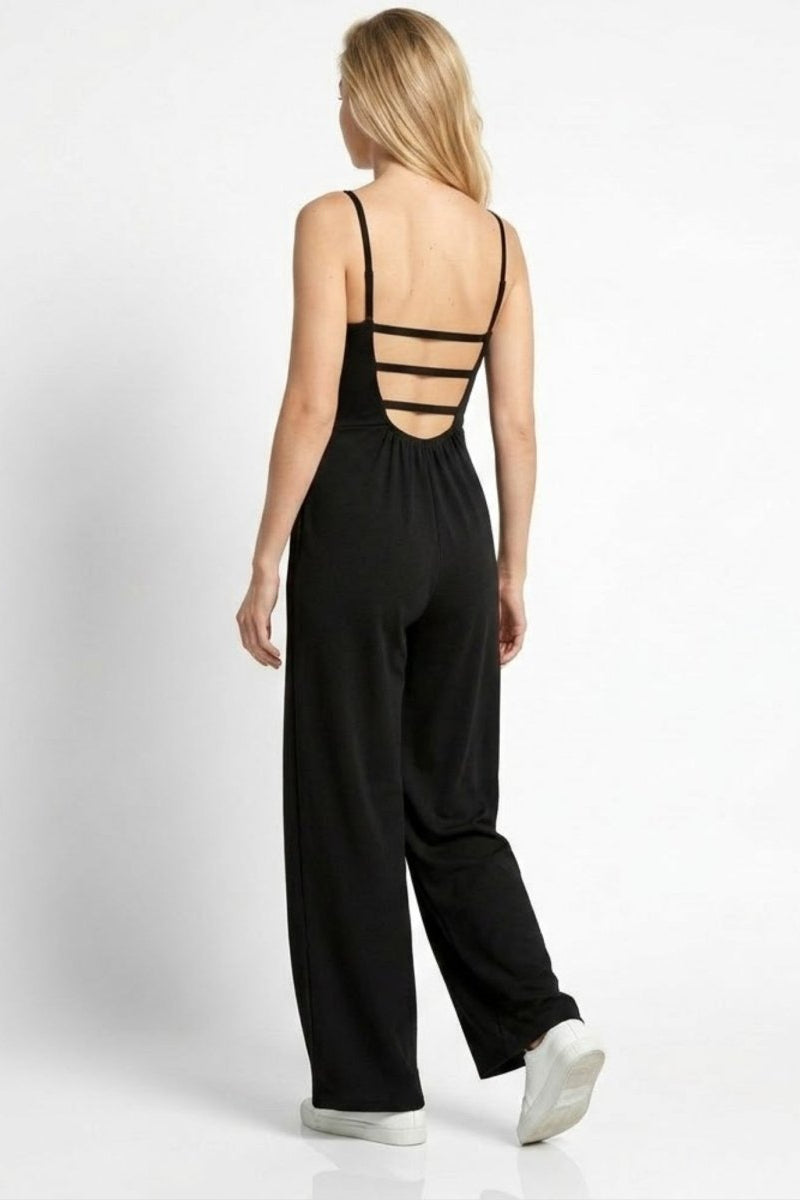 Back view of woman wearing Fenlo Form black jumpsuit featuring a multi-strap open back design