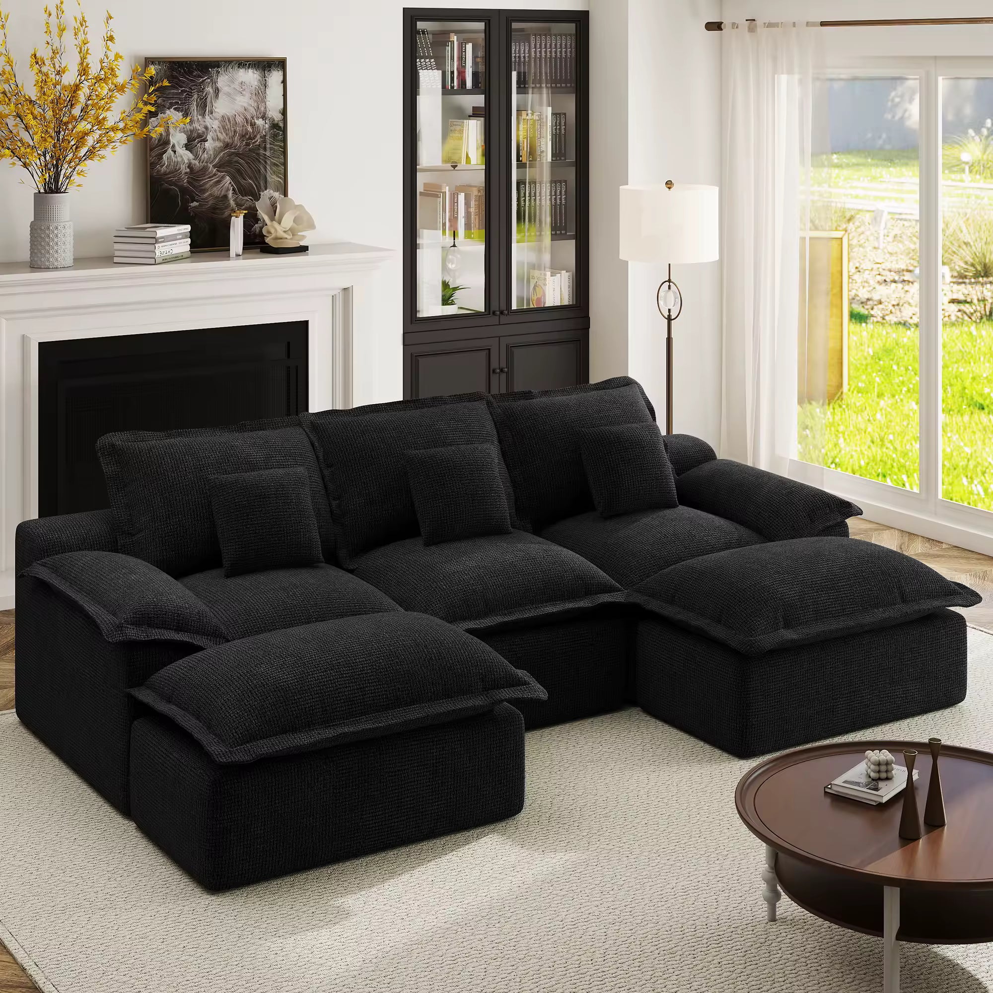 Cozy night setting featuring a black U-shaped modular sofa with plush cushions under warm floor lamp lighting.