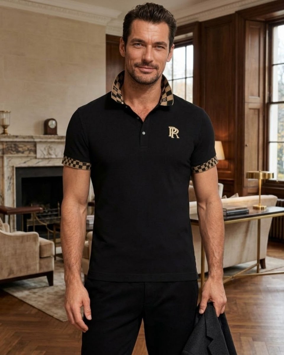 A man wearing a black short-sleeve polo shirt with a patterned beige and black collar and sleeve cuffs, featuring a gold embroidered 'R' logo on the chest. He is standing in a luxurious room with wood paneling and a fireplace.