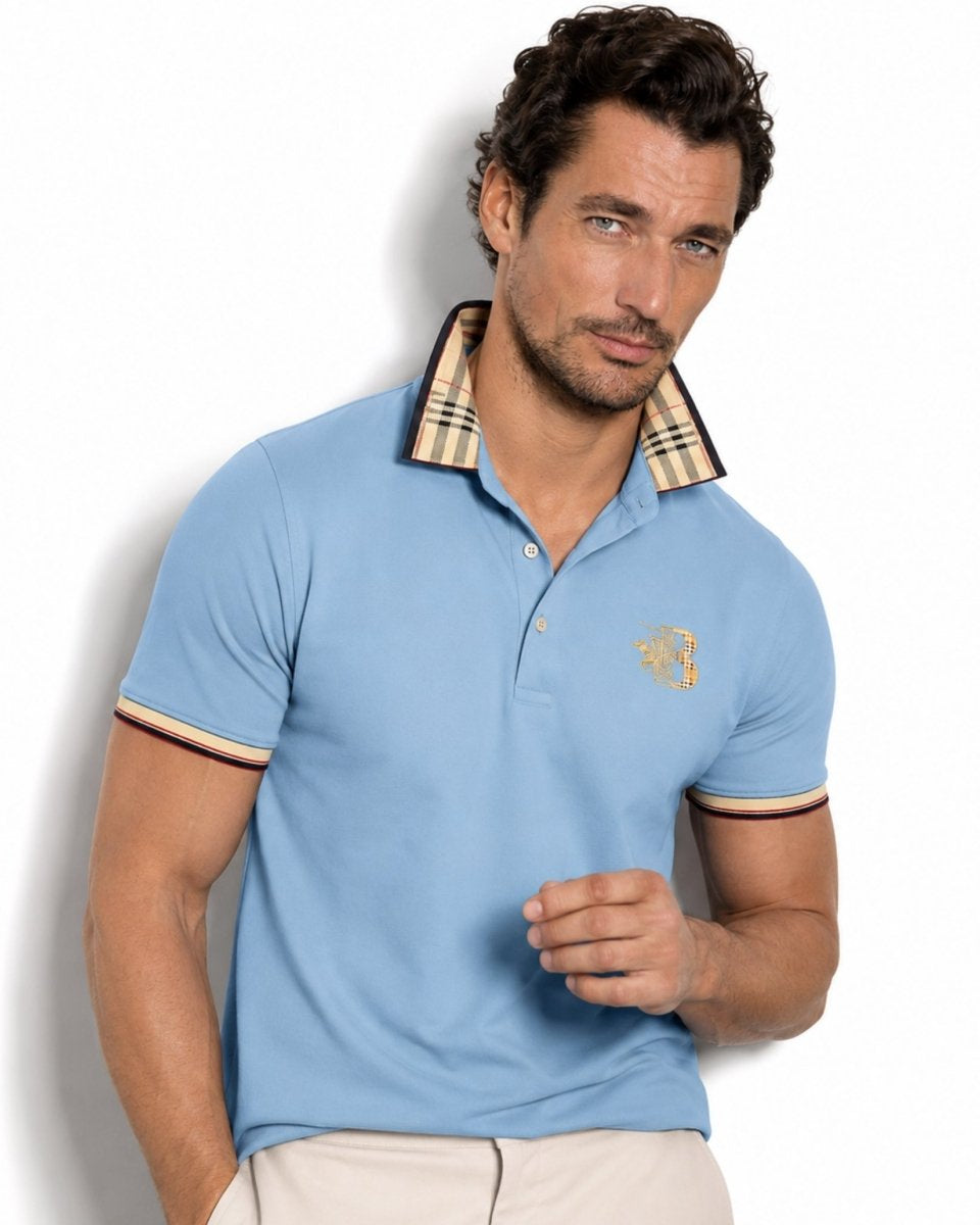 Man wearing a light blue polo shirt with a brand logo on a white background
