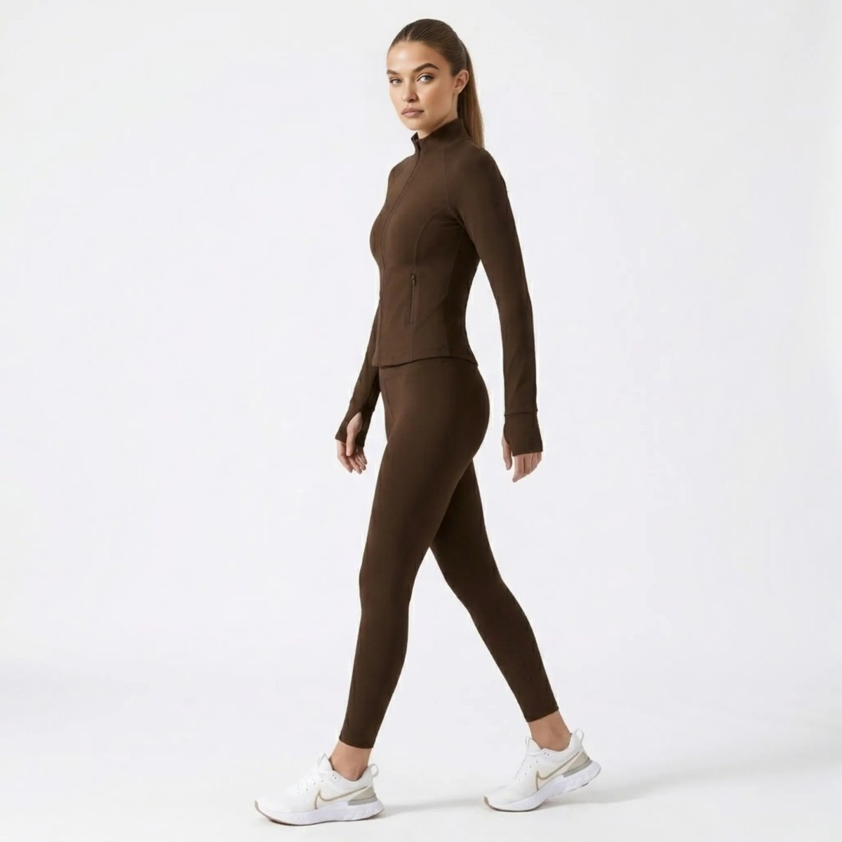 Side profile of woman walking in brown mock neck workout jacket
