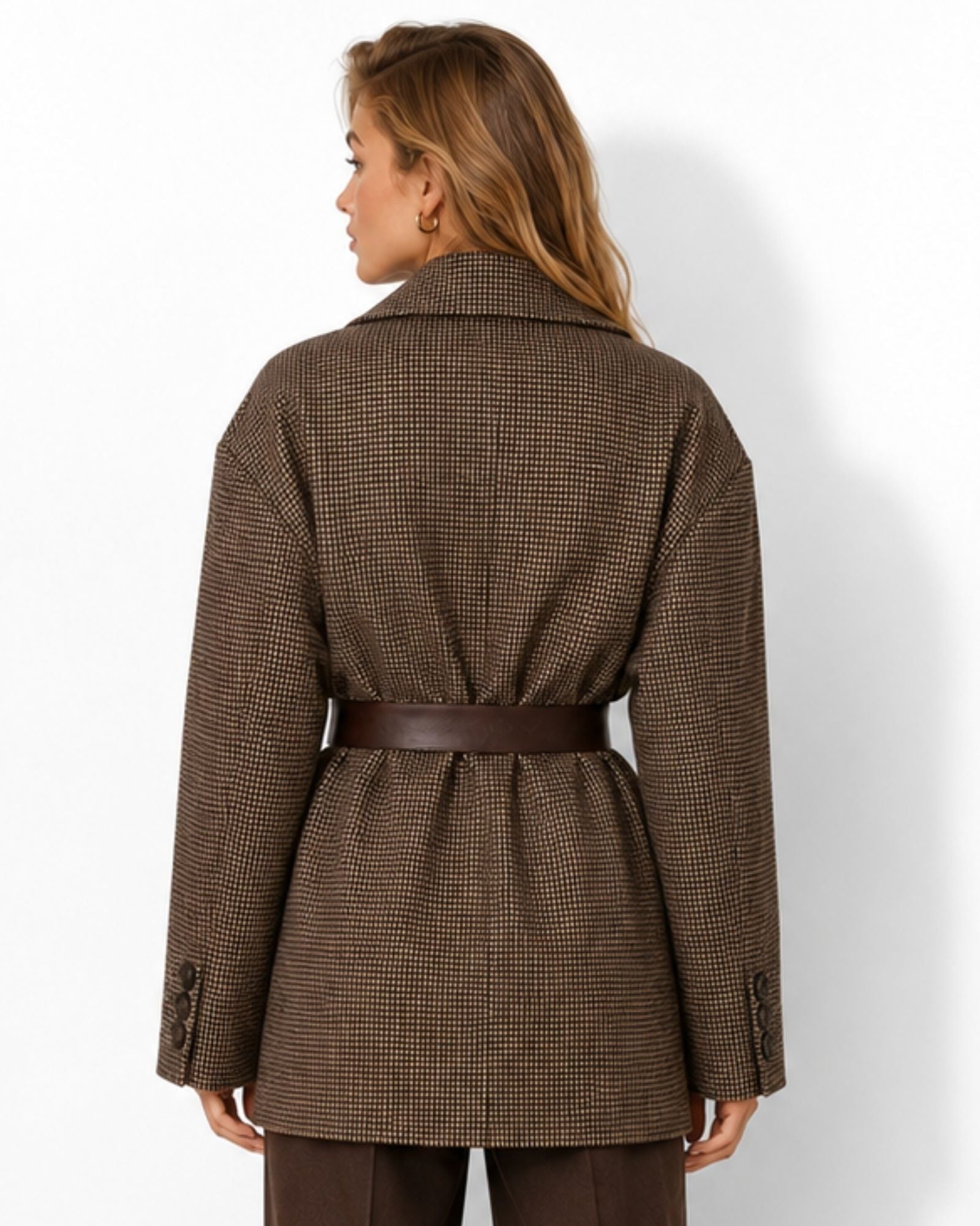 A woman shown from the back wearing a brown and black micro-check patterned coat with a matching brown belt, photographed against a clean white studio background.