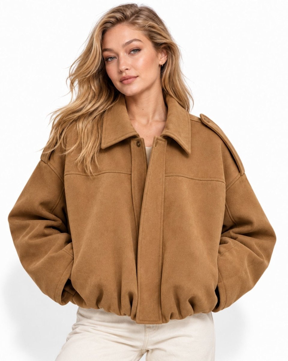 A woman wearing a cropped camel brown suede jacket with a wide collar and front button closure, paired with off-white pants, against a clean white background.