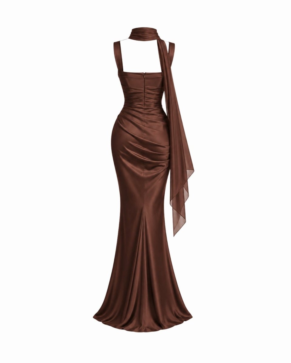 A floor-length brown gown with a halter-style neckline, ruched bodice, and draped sheer fabric detail, shown on a plain white background.