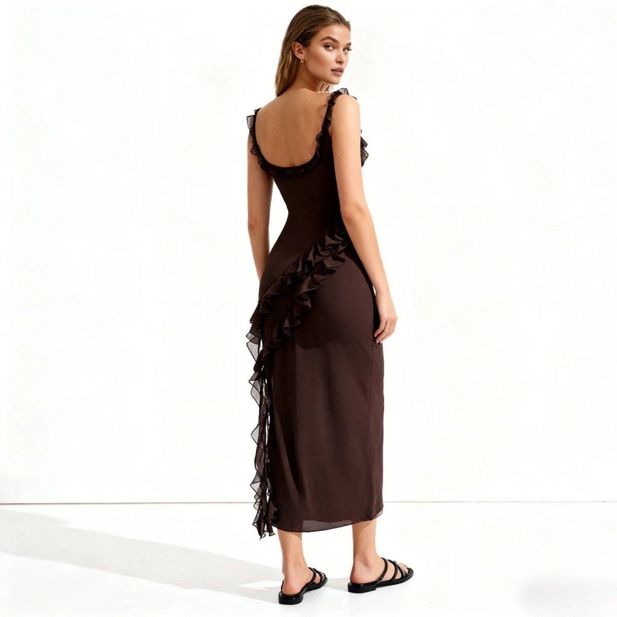 Woman wearing a brown Kouvr dress with ruffled details on a white background