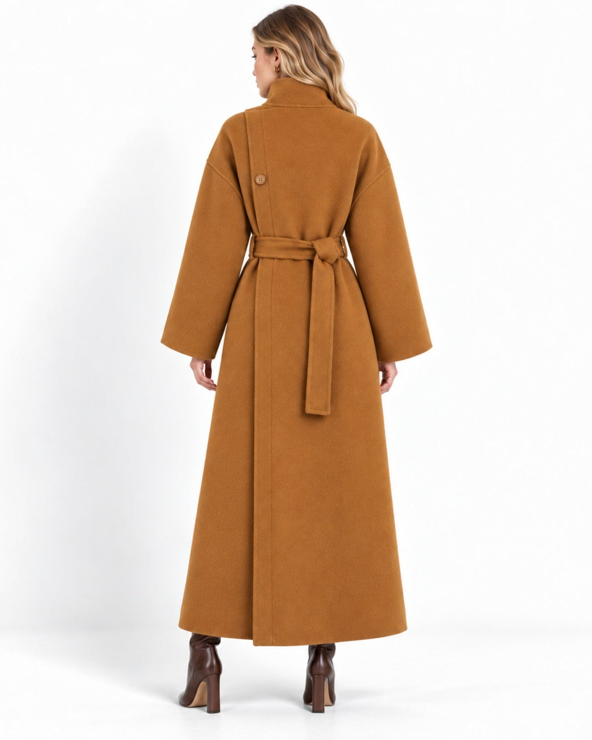 A woman shown from the back wearing a long camel-brown belted coat and brown heeled boots against a plain white studio background.