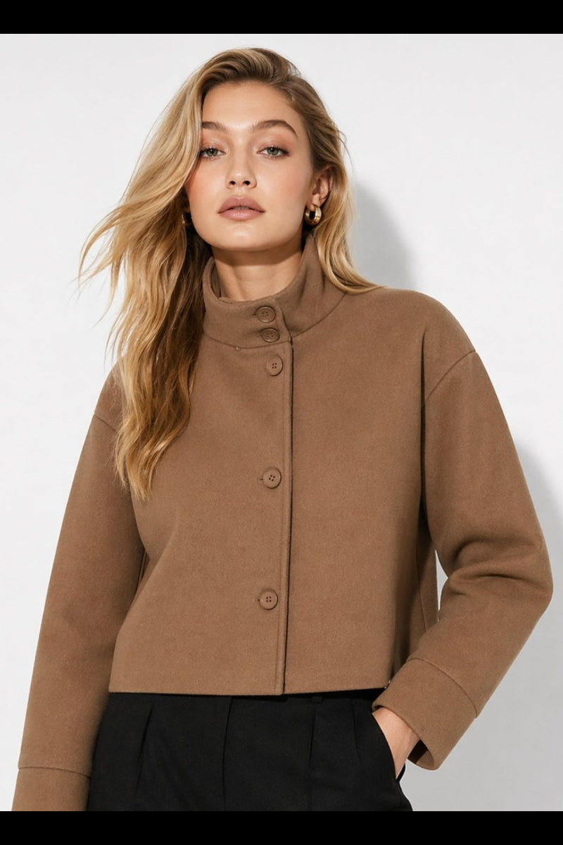 Woman wearing Fenlo Form brown wool blend cropped funnel neck jacket with black trousers looking elegant.