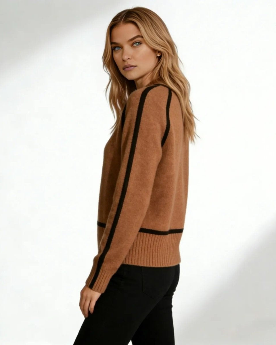 Side profile of a woman wearing a brown turtleneck sweater showing the black piping detail along the arm and shoulder.