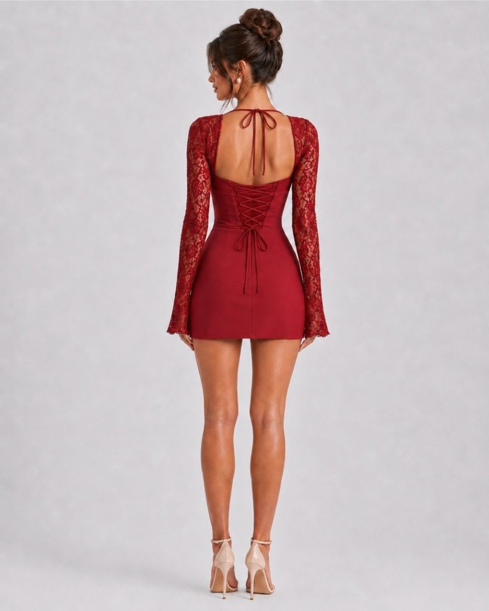 A woman shown from the back wearing a burgundy lace long-sleeve mini dress with a lace-up open back, paired with beige high-heeled sandals, against a light gray studio background.