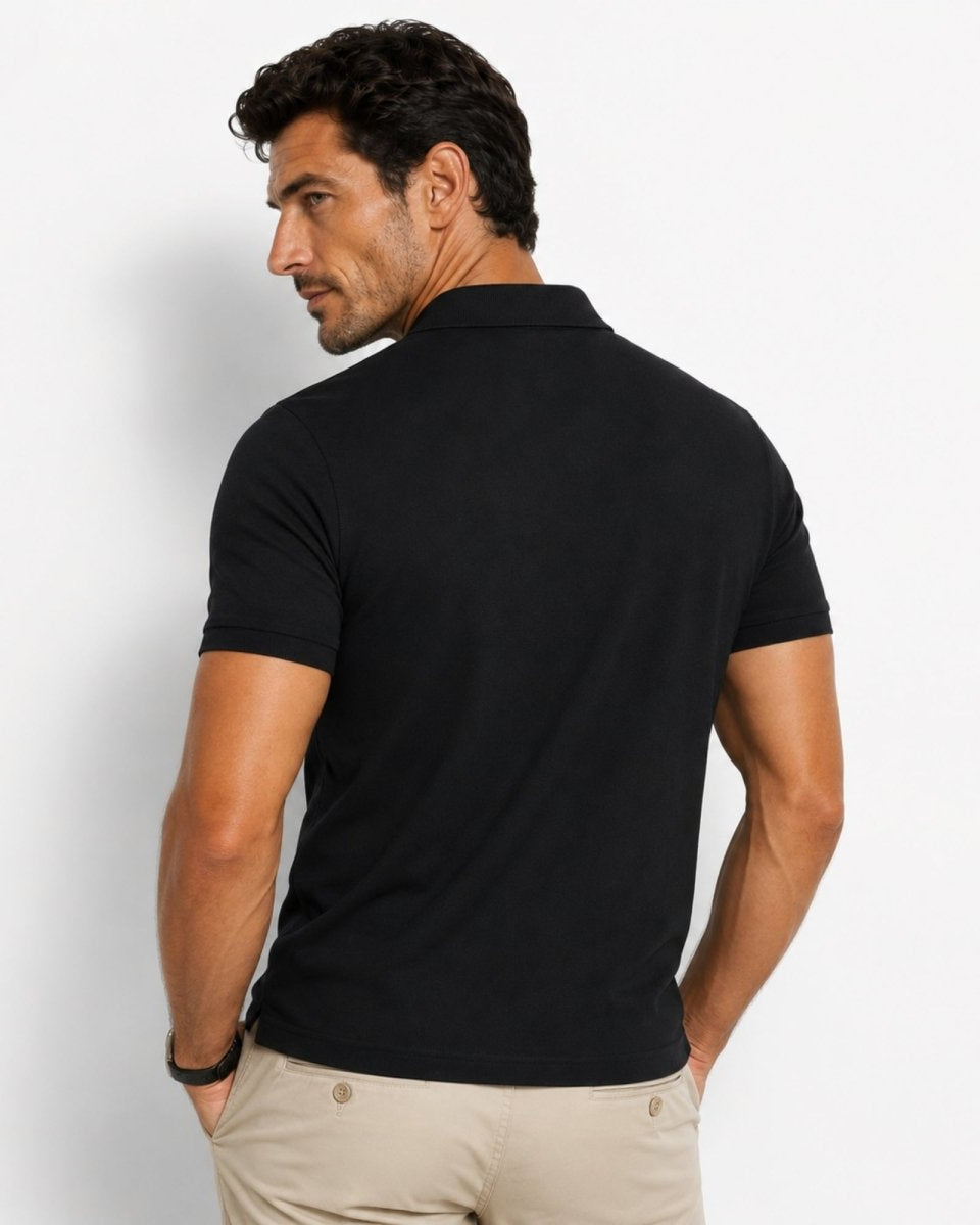 Man wearing a black polo shirt on a light gray background