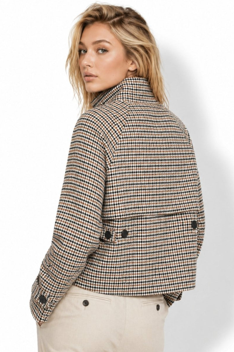 Back view of a women's cropped houndstooth jacket featuring a structured back storm flap with button accents.