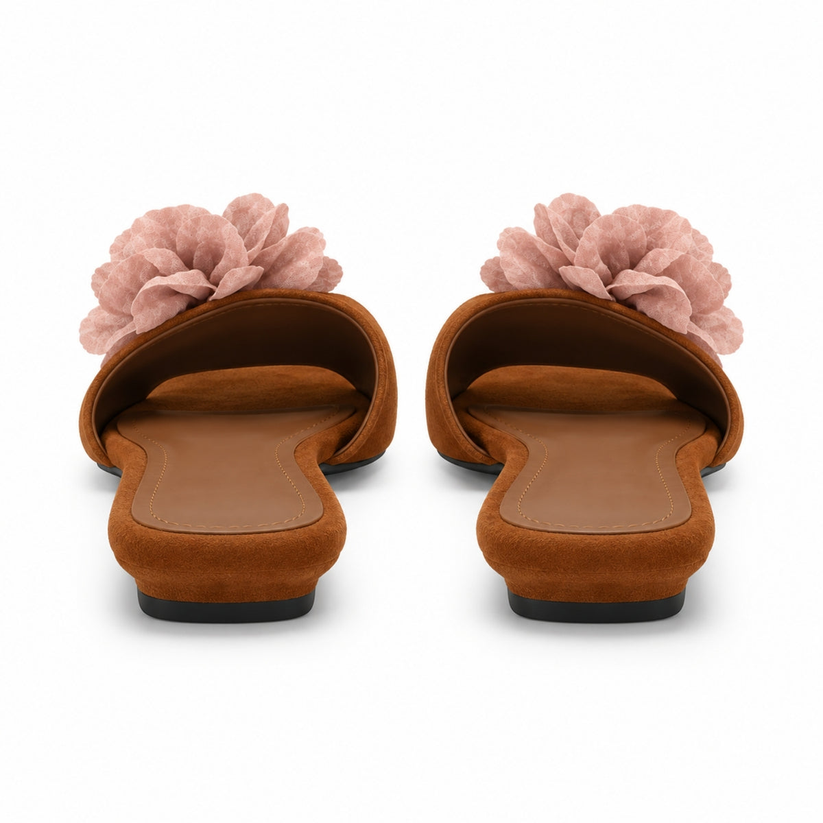 A pair of women's slide sandals viewed from the back, featuring a warm brown suede-like upper with a large dusty pink fabric flower on top, set against a plain white background.