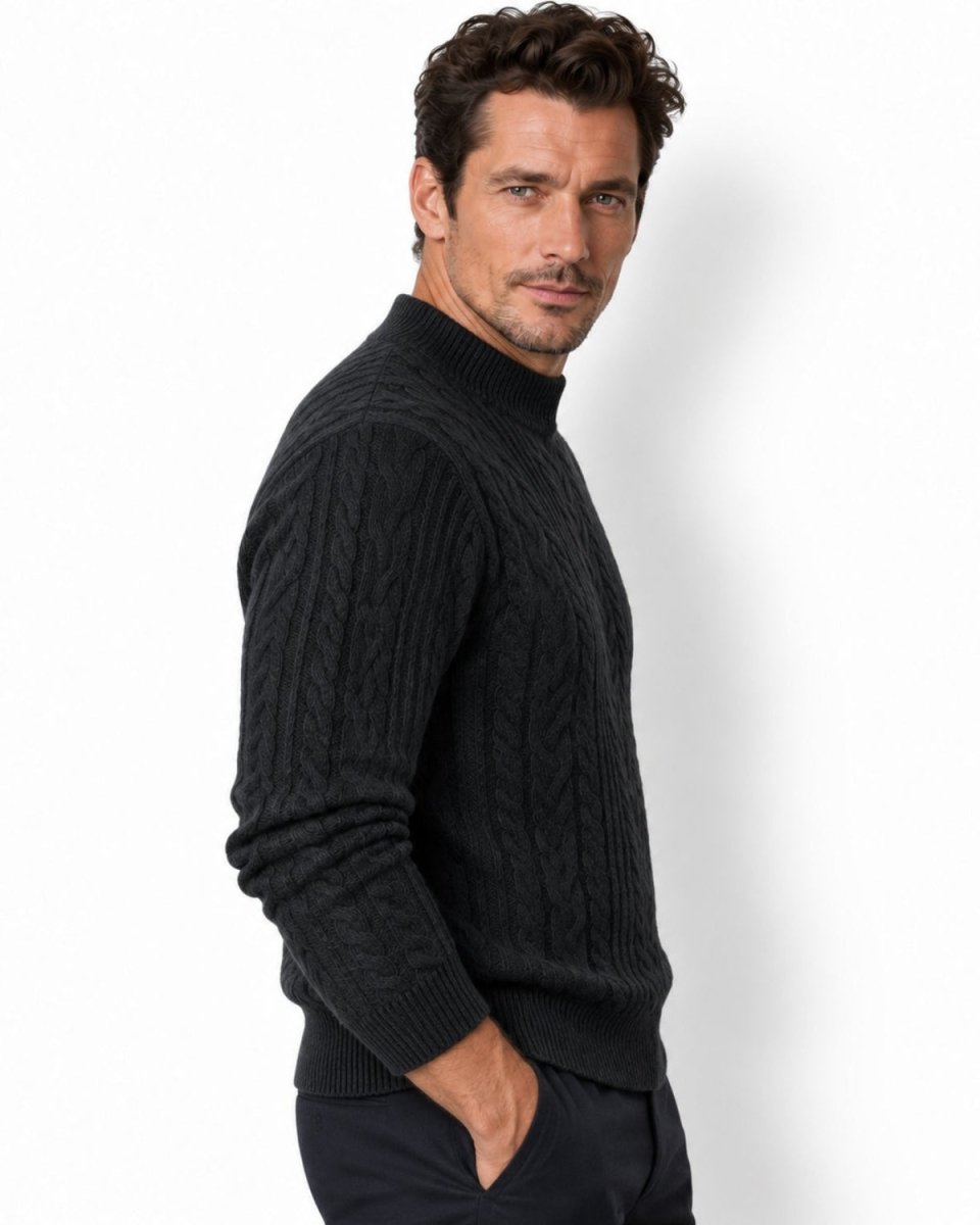 A man wearing a dark grey cable-knit mock neck sweater, shown from a side profile against a clean white studio background.