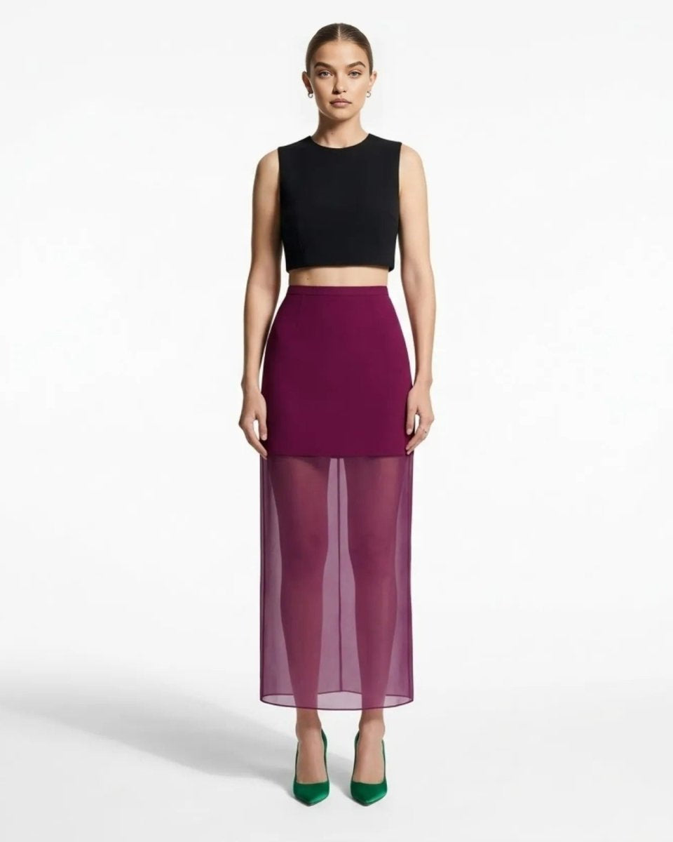 Full length view of dark purple mesh panel evening skirt styled with black crop top and green silk heels.