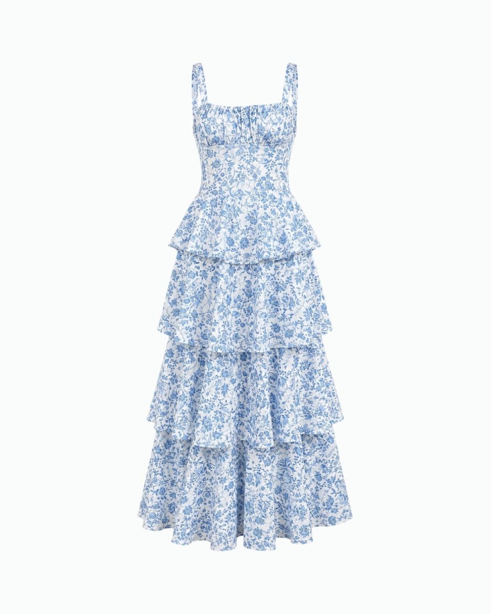 A sleeveless tiered maxi dress with a blue and white floral print, featuring a smocked bodice and thin shoulder straps, shown against a plain white background.