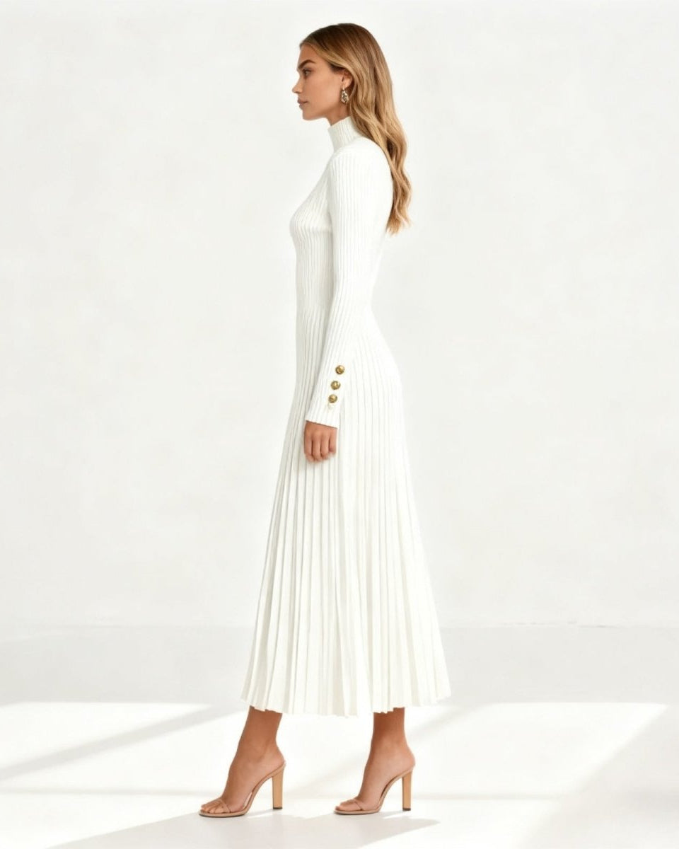 Side profile of a model in the Dianne long sleeve turtleneck dress in white, highlighting the A-line pleated skirt and gold button cuff details.