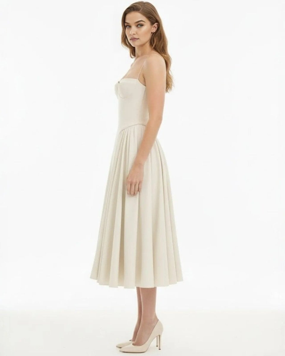 Side profile of the ecru fit and flare midi dress showing the sculpted waist and full skirt.