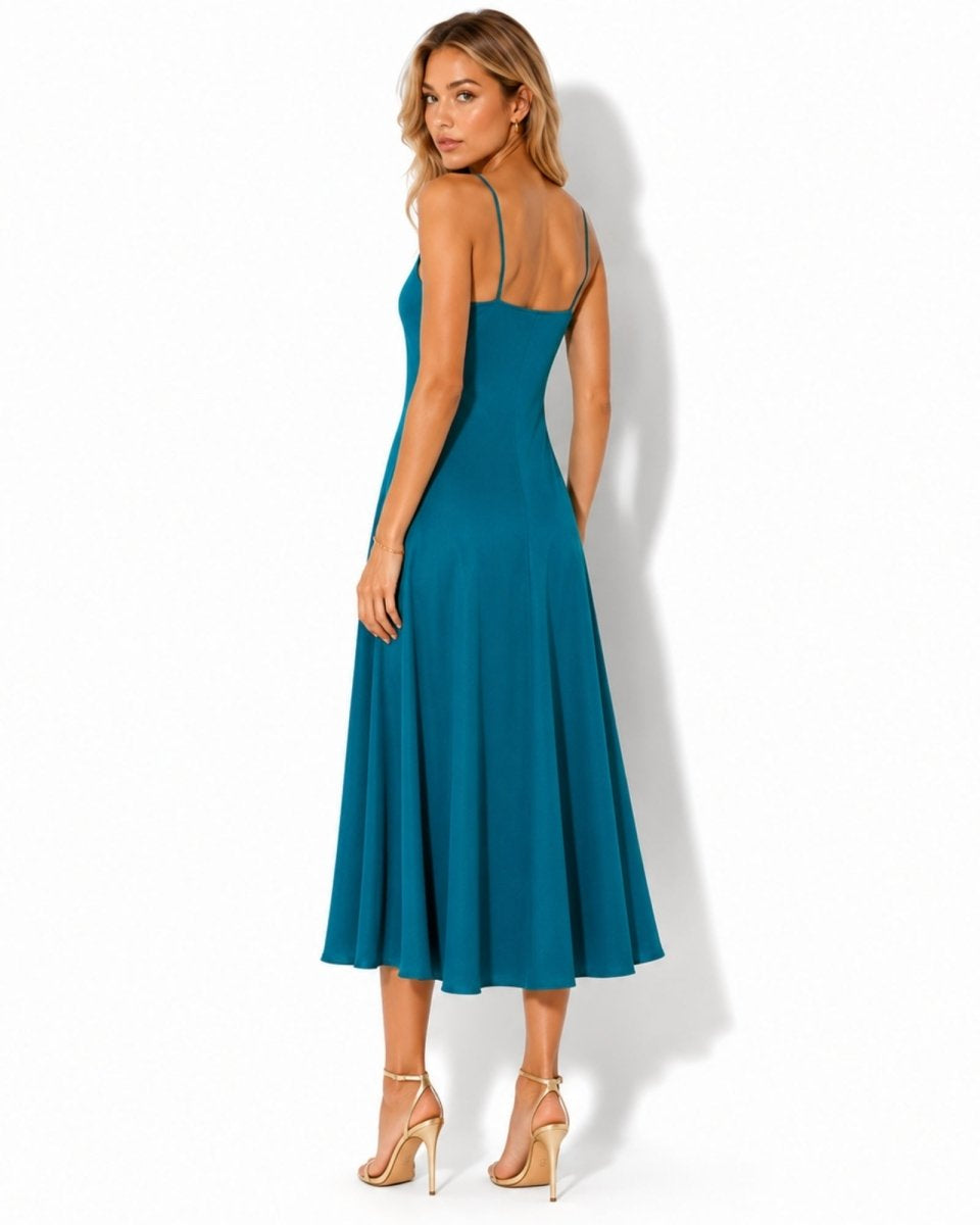 Back view of a flowy blue linen midi dress showing delicate shoulder straps and a smooth, elegant drape.