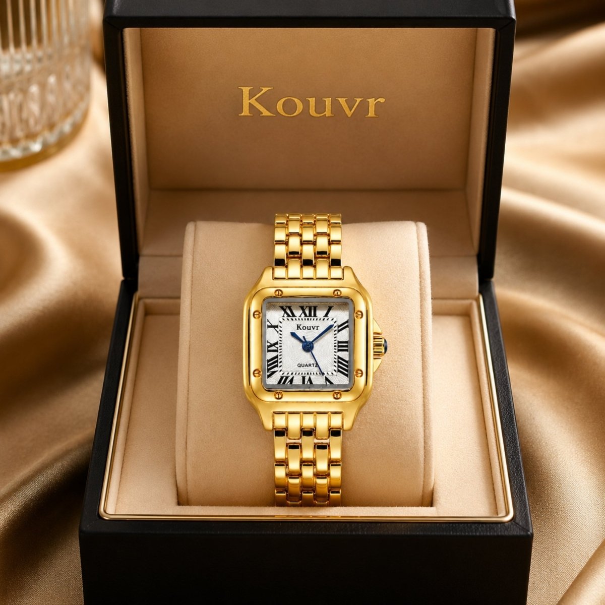Close up of Kouvr women's gold dress watch featuring a brilliant crystal diamond-style bezel and textured white dial inside a jewelry box.