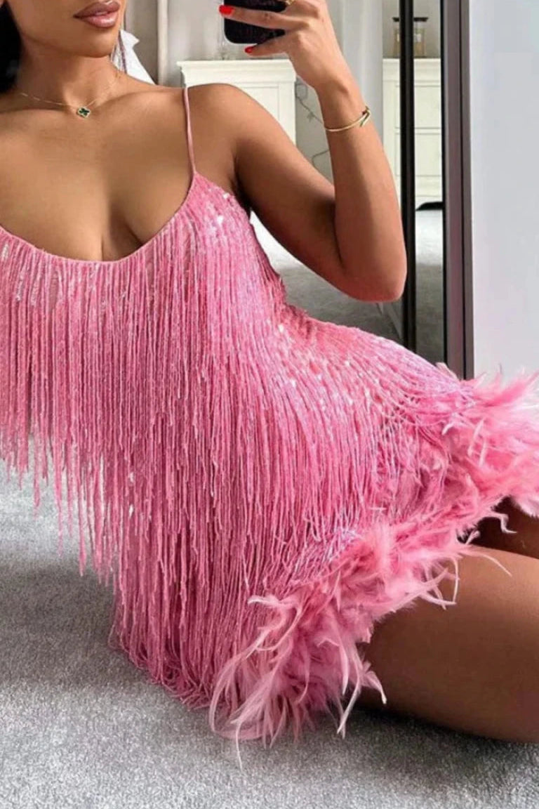 Person wearing a pink fringe dress sitting on the floor.