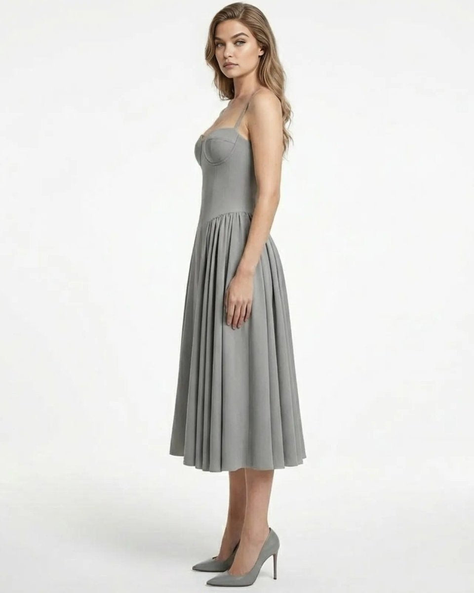 Side profile of a model in the Evdokia grey midi dress, showcasing the fit-and-flare silhouette and structured bodice.