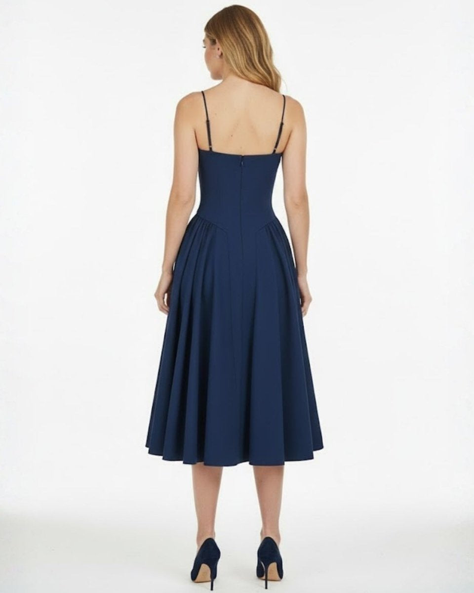 Back view of the Evdokia dress in navy, displaying the thin spaghetti straps and concealed zipper closure on the model.